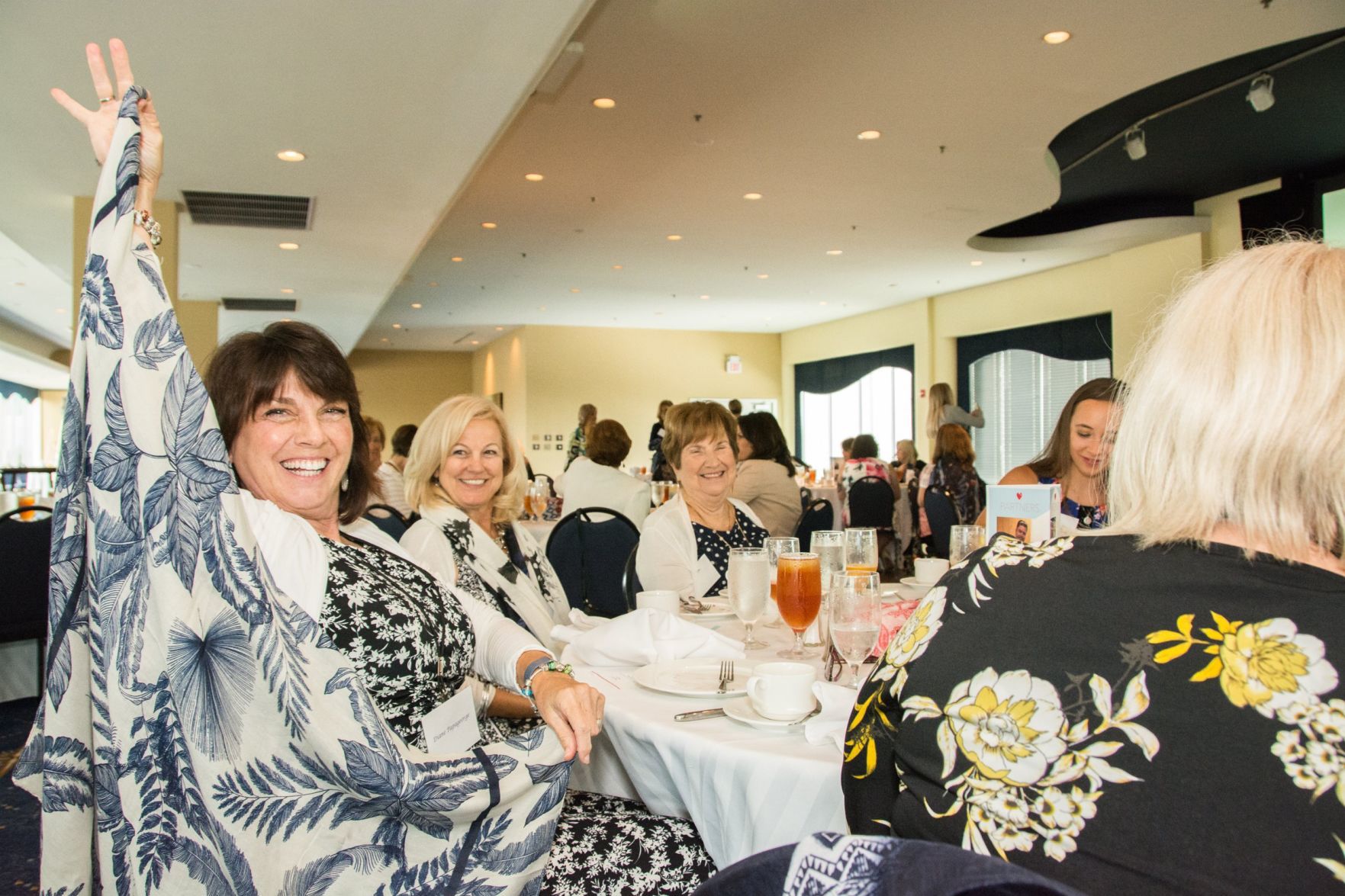 A guest of the event shows off her scarf she selected, as scarves have become a tradition of the luncheon
